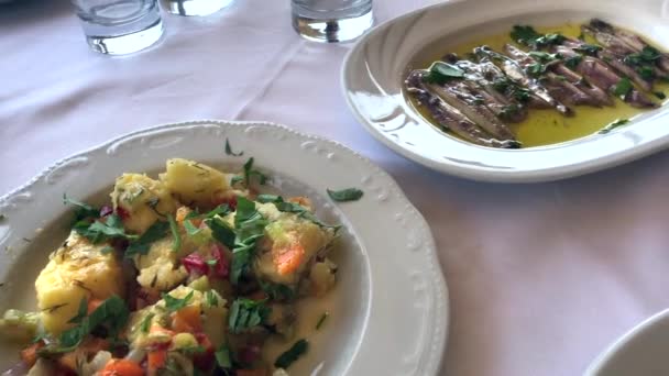 Греческий картофельный салат и рыба Гаврос с хлебом с оливковым маслом, панорама камеры . — стоковое видео