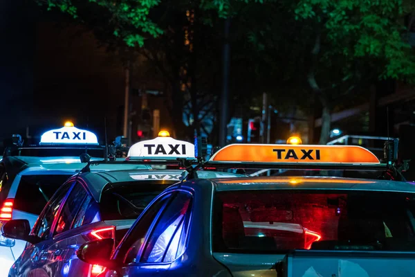 Táxis em uma fileira com seu sinal de táxi no telhado iluminado à noite em Sydney, Austrália — Fotografia de Stock