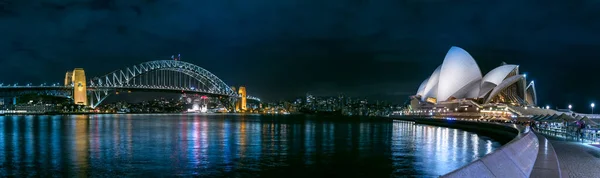 Panoramic view of the Sydney bridge and the Opera House at night. — Stock Photo, Image