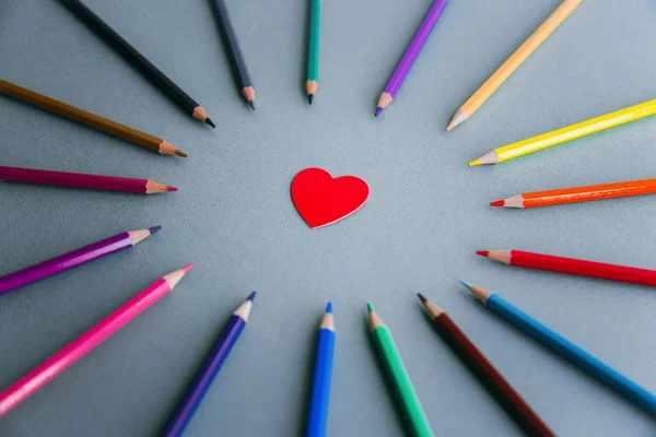 love of drawing: a circle of colored pencils, in the center of the circle is a red heart