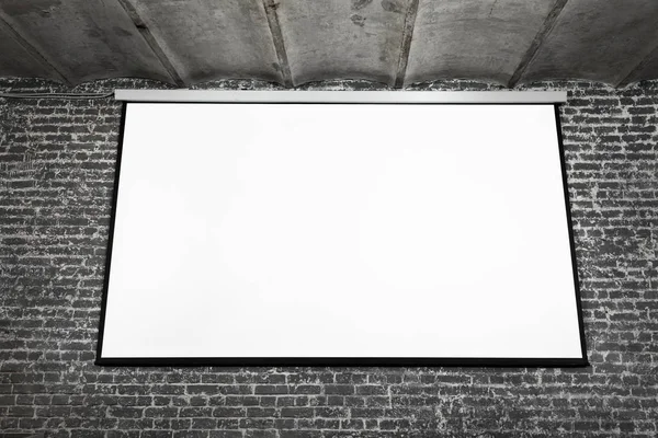 Image of white projector screen on grey brick wal — Stock Photo, Image