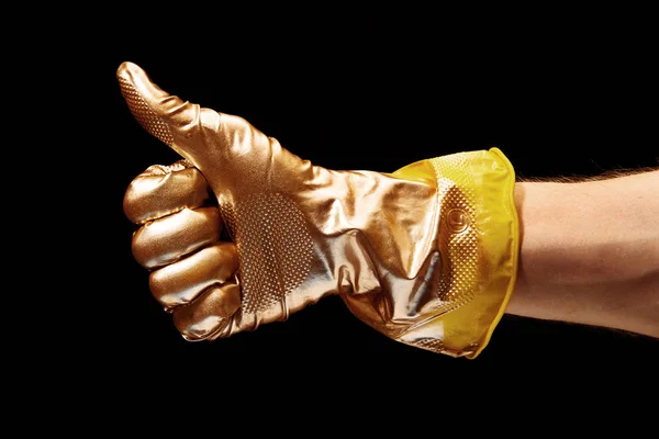 Bild av guld målade Som gest av handen i gult gummi handske på svart bakgrund — Stockfoto