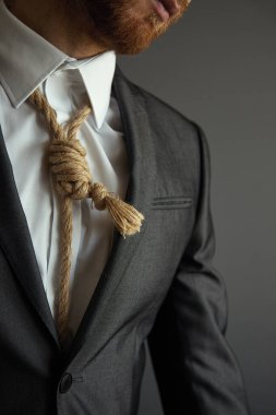 Zor durumdaki iş imajını kabul et. Boyununda kravat yerine Lynch ilmiği olan takım elbiseli bir adam..