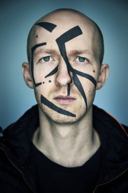 Özel kamuflaj makyajıyla yüzünü kamera tanıma programından saklayan bir adamın portresi. Büyük şehir konseptinde dijital gizlilik.