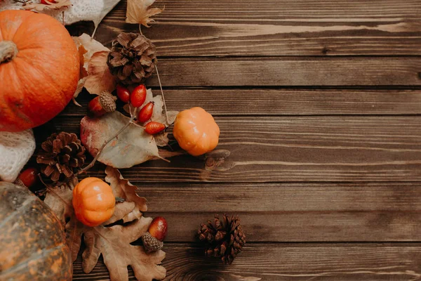 Thanksgiving background: Apples, pumpkins and fallen leaves on wooden background. Copy space for text. Halloween, Thanksgiving day or seasonal autumnal