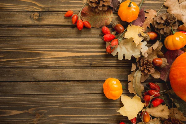 Thanksgiving background: Apples, pumpkins and fallen leaves on wooden background. Copy space for text. Halloween, Thanksgiving day or seasonal autumnal