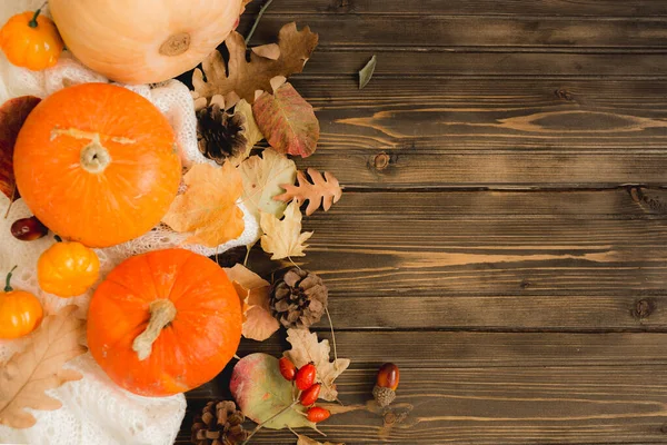 Autumn background with colored leaves and pumpkins on wooden board — Stock Photo, Image