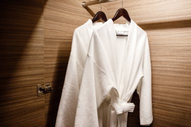 Dolapta asılı iki beyaz duş önlüğü