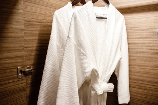 Dolapta asılı iki beyaz duş önlüğü