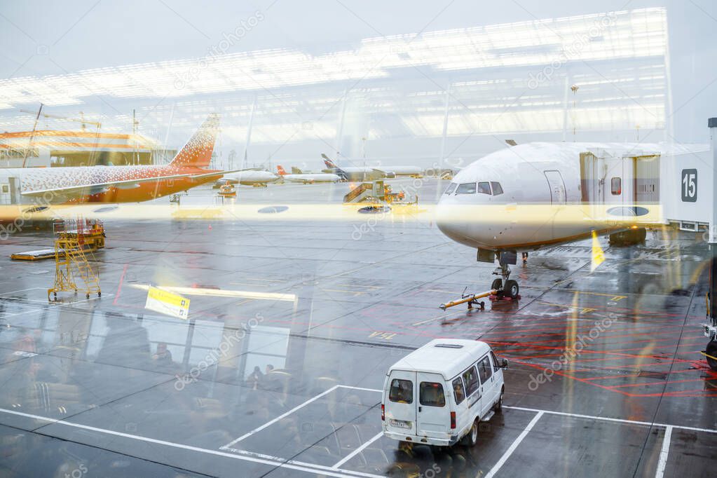 Busy airport view with airplanes and service vehicles. Travel and industry concepts