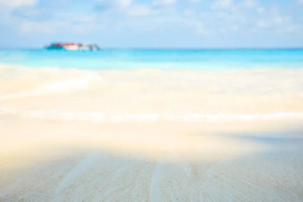 Blur summer white sand beach with sparkling sea water
