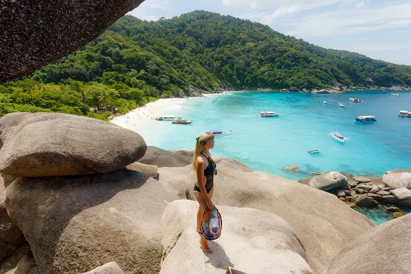 Genç bir kadın Similan adasında yelkenli kayanın üzerinde duruyor. Özgürlük yolcusu kadın Similan Ulusal Parkı, Phuket, Tayland 'da Similan No.8' de harika bir tabiata sahip. Seyahat kavramı