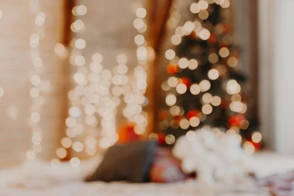 Ağaçlı ve neşeli Bokeh ışıklandırmalı, bulanık tatil geçmişi olan Noel odası.