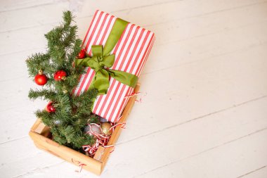 Noel kompozisyonu. Hediye, köknar ağacı dalları ve beyaz ahşap arka planda noel ağacı topları. Kış, yeni yıl konsepti