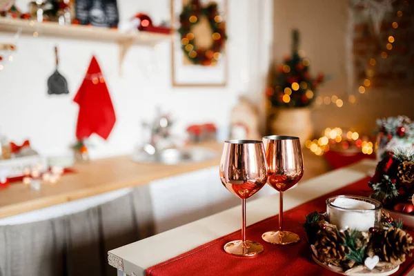 Noel ağacı ve parlak ışıklarla donatılmış güzel bir mutfak, ana planda tatil gözlükleri, bulanık bir arka plan.