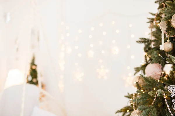 Noel ağacı ve parlak ışıklarla süslenmiş güzel bir tatil odası. Fotoğraf arkaplanı için odak dışı çekim. Bulanık Noel arkaplanı