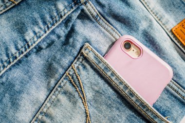 Kot cebinde Modern akıllı telefon, yakın çekim, kot pantolon cebinde cep telefonu, denim arka plan doku