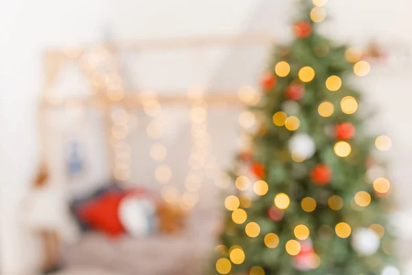 Ağaç ve şen şakrak ışıklandırmalı, bulanık tatil geçmişi olan bir Noel odası. Yeni yıl arkaplanı