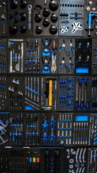 Professionella arbetsverktyg hängande på väggen som bakgrund. Verktyg på verktygsstall — Stockfoto
