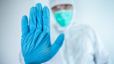 Beyaz erkek doktor koruyucu giysi ve maske takıyor dur işareti yapıp hayır diyor. Virüs hastalığını reddediyorsan, kapat. Beyaz arka planda izole edilmiş. Tıbbi ve sağlık hizmetleri kavramı.