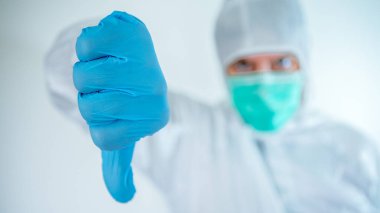 Erkek doktor işaret ediyor. Koruyucu takım elbiseli ve maske takan beyaz adam kötü sonuç veriyor. Tıbbi ve sağlık konsepti, biyolojik tehlike Çin koronavirüsü. Salgın COVID-19.