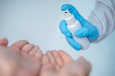 Eldivenli bilim, Corona virüsü için dezenfektan kullanıyor. Coronavirus kırmızı modelini tutan kadın eller. Covid-19 enfeksiyonuna karşı önleyici önlemler. Ntibakteriyel alkol bazlı el yıkama spreyi.