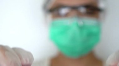 COVID-19 için pozitif test tüpü taşıyan Asyalı bir kadının yavaş hareketi. Çin 'in Wuhan şehrinde bulunan yeni bir koronavirüs. Beyaz eldivenli ve maske takan bilim adamı Dan.
