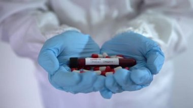 4K, koruyucu ilaç, virüse karşı COVID-19 hapları doktor elinde. Coronavirus 'u tedavi etmek için. Corona virüsü aşı araştırması için kan örneğini enfekte etti. Tıbbi konsept aşı tedavisi - Dan