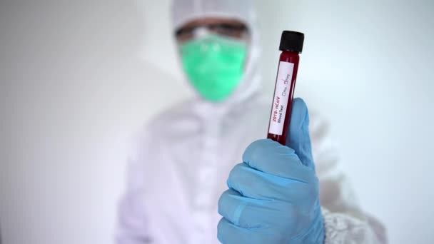 保護スーツの手を指している男性科学者 Covid 19の血液サンプルの陰性の検査管を持ち 親指を放棄した白人男性は 良い結果を意味します コロナウイルス ダンのワクチン研究 — ストック動画