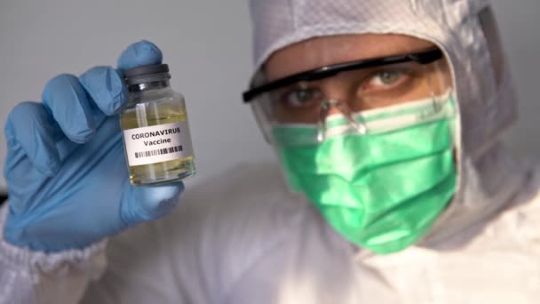 保護服を着た科学者は コロナウイルスのワクチンを持っています Covid 19のワクチン接種 2019年 中国武漢で発見 流行ウイルスの概念 医療とヘルスケアの概念 Dan — ストック動画