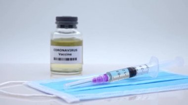 4K, bilimsel kimya laboratuvarında Covid-19 için yüz maskesi aşısı ve şırınga enjeksiyonu. Solunum yoluna saldıran grip koronavirüsü patojeni. Salgın virüs enfeksiyonu kavramı - Dan