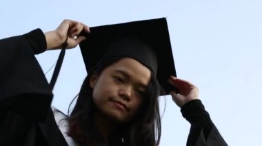 Mezuniyet - havada uçan şapkalar, parlak güneşli bir günde Asyalı mutlu kızlar grubu tarafından havaya şapkalar atılır. Düşük açı - Dan