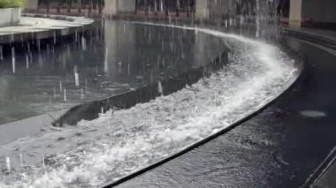 Taipei şehrindeki Daan parkının ortasındaki büyük yapay şelalenin yavaş hareketi. Kaya duvarından aşağı su dökülüyor. Güzel çeşme Dan.