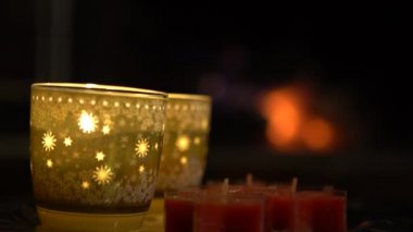 4K Noel süslemesi mumlar ve yanan şömineli arka plan şöminesi ve kırmızı kömürlü.