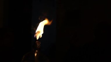 Karanlık bir bölgede izole edilmiş geleneksel gazyağı lambasının yavaş hareketi. Karanlıkta ışık saçan toprak ya da kil lamba. Karanlığı alevle yok etme kavramı. Lambanın yağı ve pamuğu var.