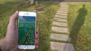 Taipei, Tayvan-06 Ağustos 2016: 4K Pokemon Go uygulaması parkta oynanıyor, bir adam tarafından oynanan akıllı bir telefon ekranda artırılmış gerçeklik mobil oyununun GPS 'ini gösteriyor.