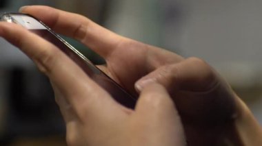 Yavaş çekim. Yakın çekim. Asyalı kadın akıllı telefonuyla oynuyor. İnternette gezinmek için cep telefonunu kullanarak sosyal ağları, e-postaları, resimleri, telefon cihazına yapılan metinleri görmek.