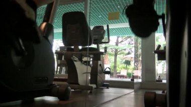 Spor Salonunda 4K Erkek Ayak Pedalı Bisiklet Makinesinde. Genç adam bir otelin spor salonunda egzersiz yapıyor. Sağlıklı Yaşam Tarzı Dan