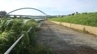 Beyaz adam ve Asyalı kadın Taipe şehrinde nehrin kenarında koşuyorlar. Güneşli bir yaz gününde Tayvan 'da güzel manzaralı koşan bir çift. Egzersiz Konsepti. Spor ve spor yaşam tarzı Dan.