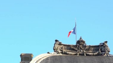 Fransa 'da bayrak direğinde rüzgarda dalgalanan Fransız bayrağının yavaş hareketi. Fransız bayrağının yavaş çekimde mavi gökyüzünün önünde sallanışı. Gerçek bir kumaş dokusunu kapat Asteğmen çırpınan Dan