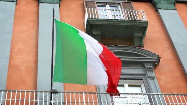意大利城市的旗杆上飘扬着意大利国旗的慢动作 意大利国旗在建筑物里一天到晚缓缓飘扬 靠近真实的面料纹理标志着顺风飘扬 — 图库视频影像