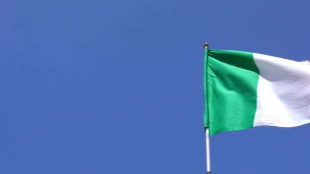 イタリアの都市の旗竿で風に揺れるイタリア国旗のスローモーション 青空の前でイタリアの旗がゆっくりと動きます 生地の質感を閉じますエンサインなびかせダン — ストック動画