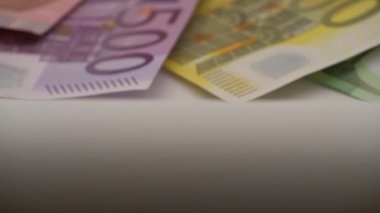 Bir madeni paranın farklı değerlerde banknotları olan 4K kapanışı. Nakit para geçmişi. Gerçek 100 Euro. İyi kazançlar. Maaş çıkarıyorum. Yüzde yüz. Başarılı bir iş. Dolly kayıyor.