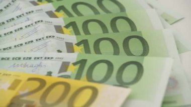 Bir madeni paranın farklı değerlerde banknotları olan 4K kapanışı. Nakit para geçmişi. Gerçek 100 Euro. İyi kazançlar. Maaş çıkarıyorum. Yüzde yüz. Başarılı bir iş. Dolly kayıyor.