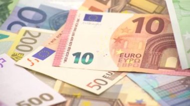 Bir madeni paranın farklı değerlerde banknotları olan 4K kapanışı. Nakit para geçmişi. Gerçek 100 Euro. İyi kazançlar. Maaş çıkarıyorum. Yüzde yüz. Başarılı bir iş. Dolly kayıyor.