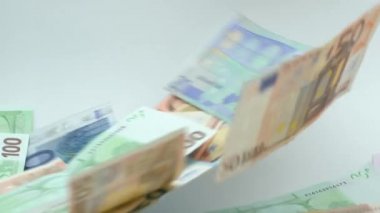 Avronun yavaş akımı uçuyor ve düşüyor. Farklı değerlerin banknotları uçar. Avro nakit para geçmişi. İyi kazançlar. Maaş çıkarıyorum. Banka depozitosu. Yüzde yüz. Başarılı iş - Dan