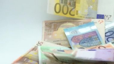 Avronun yavaş akımı uçuyor ve düşüyor. Farklı değerlerin banknotları uçar. Avro nakit para geçmişi. İyi kazançlar. Maaş çıkarıyorum. Banka depozitosu. Yüzde yüz. Başarılı iş - Dan