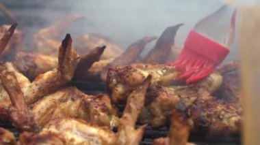 Soslu tavuk salamura edilmiş sosla kaplı Yavaş Adam Hareketi. Şef ızgarada tavuk kanadı pişiriyor. Sıcak ve baharatlı ızgara tavuk pişirmek. Izgara ızgara Dan ile pişirilen yemekler.