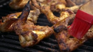 Soslu tavuk salamura edilmiş sosla kaplı Yavaş Adam Hareketi. Şef ızgarada tavuk kanadı pişiriyor. Sıcak ve baharatlı ızgara tavuk pişirmek. Izgara ızgara Dan ile pişirilen yemekler.