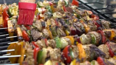 Yavaş Aşçı, sosla kaplanmış mangalda leziz şişler. Izgara et üzerinde brochette pişirmek. Izgara ızgarayla pişirilen yemekler. Dan evinin arka bahçesinde yemek pişiren adam.